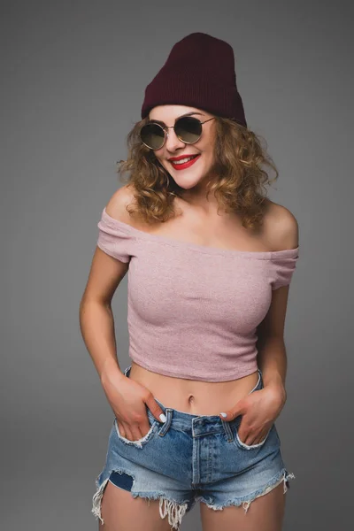 세련 된 패션 선글라스와 모자에 캐주얼 유행 젊은 여자의 초상화 스튜디오에 미소 — 스톡 사진