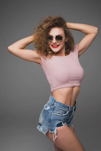 Élégant portrait de mode hipster de jeune femme décontractée à la mode en lunettes de soleil et chapeau en studio — Photo