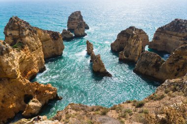 Yaz tatili kayalıklarla denizler ile kumsalda mağaralar deniz manzarası görünümünde kayaların üzerinde harcama. Yaz saati