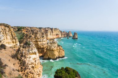Yaz tatili kayalıklarla denizler ile kumsalda mağaralar deniz manzarası görünümünde kayaların üzerinde harcama. Yaz saati