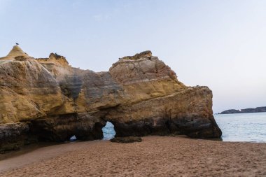 Güzel Atlantik Okyanusu görünümü ufuk kumlu plaj kayalar ve gün batımı algarve dalgaları. Yaz saati