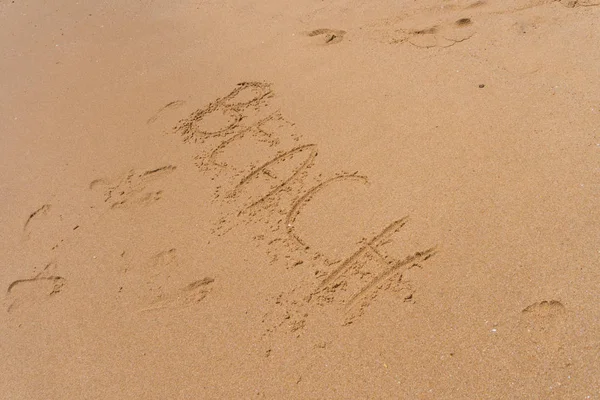 Palavra de praia na areia na praia como fundo. Hora de verão — Fotografia de Stock