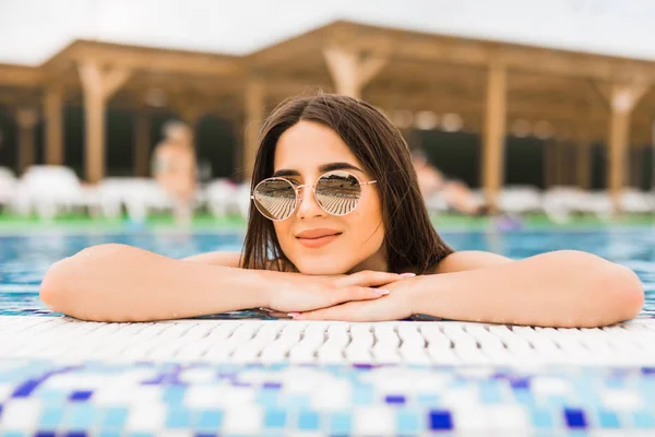 Mulher de óculos de sol perto da borda da piscina — Fotografia de Stock