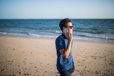 Telefon ve bkz: tropikal on sunset konuşan genç Asyalı adam