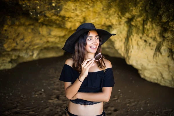 幸福美丽墨西哥女人帽子和太阳镜微笑附近的岩石海滩上夏天假期时间 — 图库照片