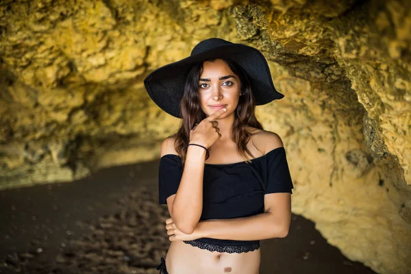 Glad vacker latin kvinna sitter nära på rocks beach kallelse sommartid — Stockfoto