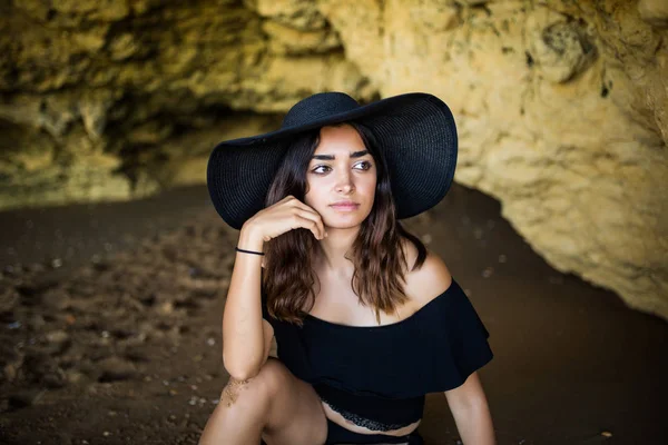 Yanında oturan mutlu güzel latin kadın plaj yaz meslek zamanında kayalar.