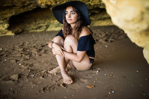 Mulher latina bonita feliz usar em chapéu sentado perto na praia rochas no verão tempo vocação — Fotografia de Stock