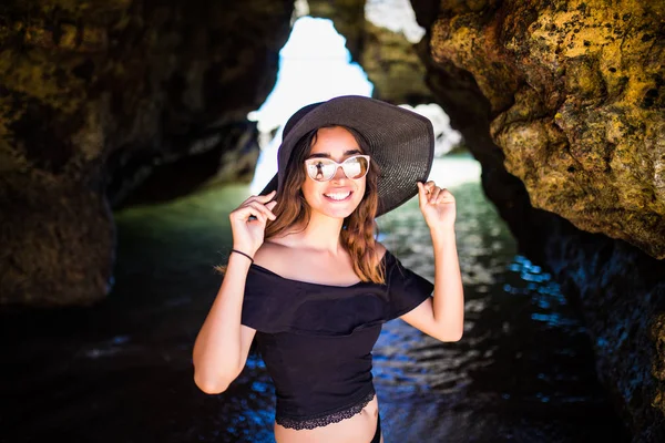 Belleza chica latina en sombrero de verano cerca de la cueva caminando en la playa o —  Fotos de Stock