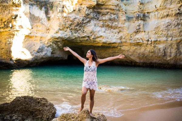 Krásné latin žena užít léto kynuté rukama u oceánu a jeskyně povolání včas letní — Stock fotografie