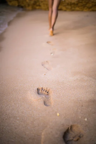 Kobieta kroki na piasku w pobliżu ocean plaża podczas chodzenia — Zdjęcie stockowe