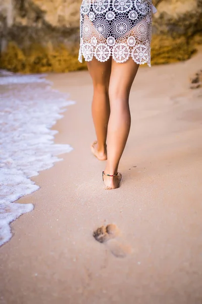 Kobieta kroki na piasku w pobliżu ocean plaża podczas chodzenia — Zdjęcie stockowe