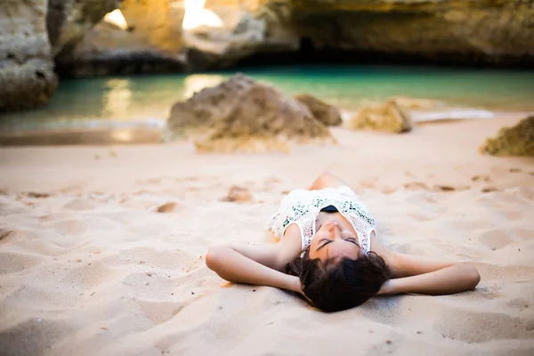 Латинская женщина отдыхает и наслаждается летним пляжным временем рядом с океанскими пещерами — стоковое фото