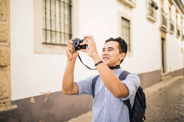 Hobby y viajar joven con la mochila tomando con su cámara — Foto de Stock