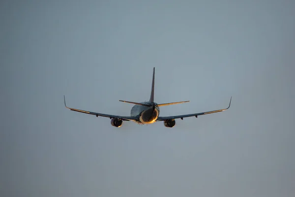 Passagierflugzeug fliegt bei Sonnenuntergang über Startbahn vom Flughafen auf. Flugzeug Abflug vom Flughafen. — Stockfoto