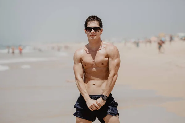 Handsome young muscular male model on the beach enjoying summer — Stock Photo, Image