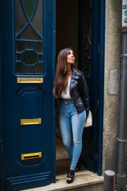 ahşap kapı arka plan üzerinde duran genç bir şirin kız portresi.