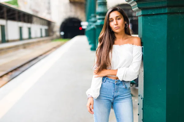 Jovem posando na plataforma na estação de trem. Esperando um trem ou metrô — Fotografia de Stock