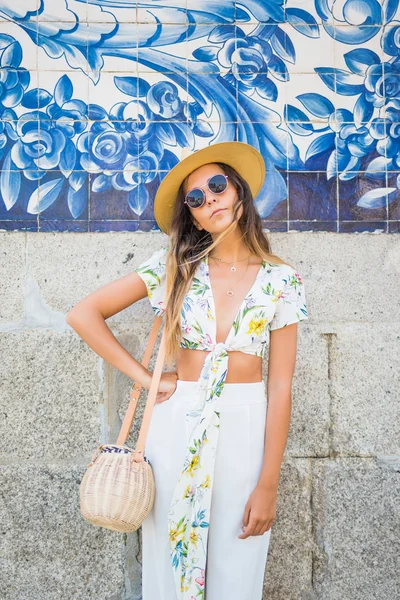 Elegancka Kobieta w pobliżu murów miejskich sobie okulary i biały t-shirt w upalne lato w mieście — Zdjęcie stockowe