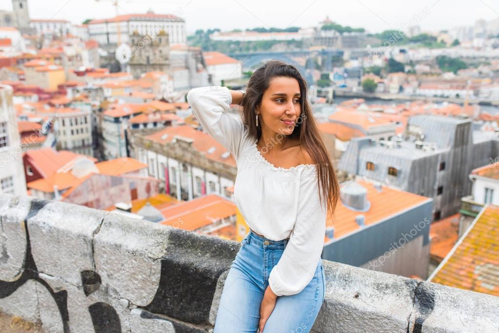 Young woman posing on panorama of Porto, Portugal.