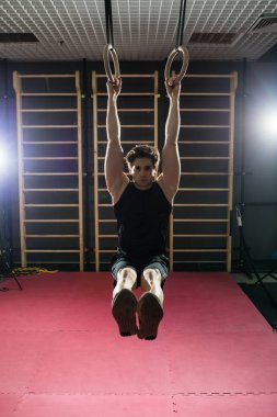 Daldırma egzersiz kullanarak yapan yakışıklı erkek fitness salonunda halkalar. Spor