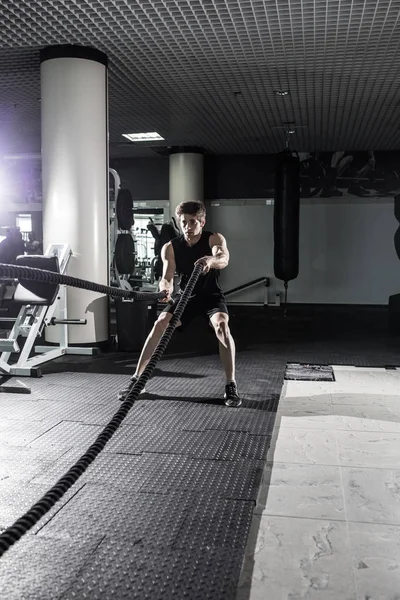 Atrakcyjny i muskularny mężczyzna pracy z ciężkim lin. Zdjęcia przystojny mężczyzna w sportowej. CrossFit — Zdjęcie stockowe