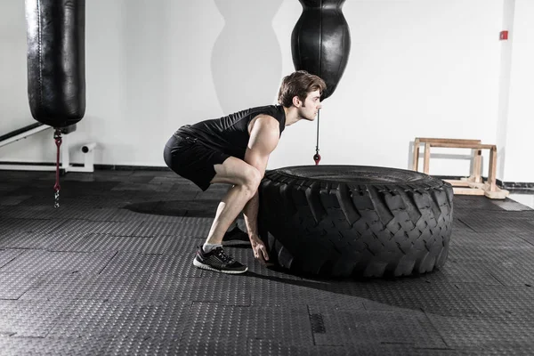 Entrenamiento con un neumático grande en el gimnasio — Foto de Stock