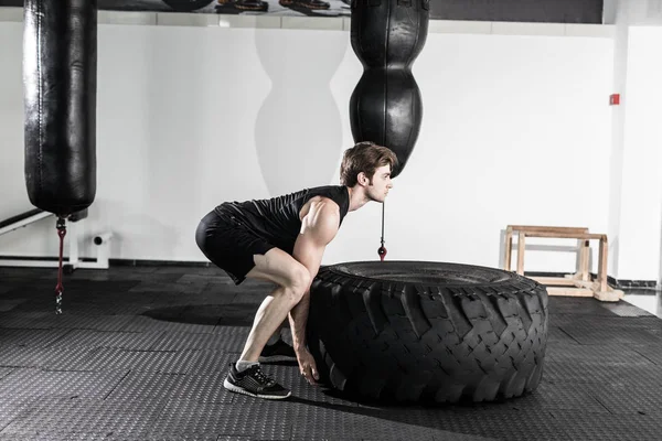 Entrenamiento con un neumático grande en el gimnasio — Foto de Stock