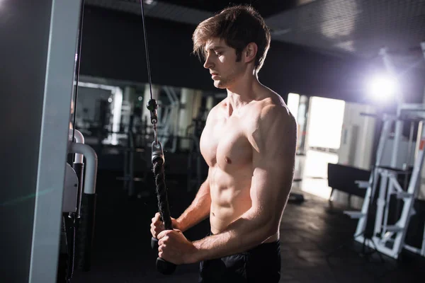 Man doing cable fly exercise in gym in fitness hall — Stock Photo, Image