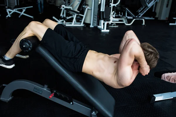 Hombre musculoso ejercitando haciendo ejercicio de sentarse . — Foto de Stock