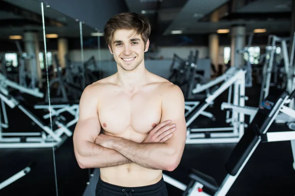 Muscular, shirtless young man resting in gym during workout, showing muscular torso, pecs and abs in the mirror at gym — Stock Photo, Image