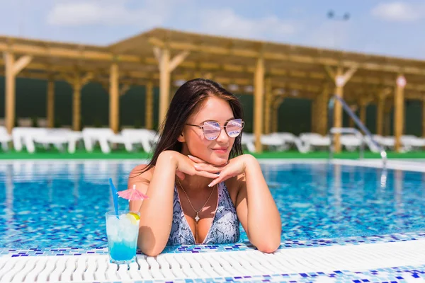 Porträtt av ung sexig tjej avkopplande vid kanten av poolen., bär baddräkt och dricka drinkar under semester. Poolparty — Stockfoto
