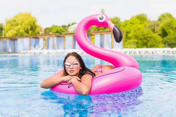 Сексуальная горячая девушка сидит на надувных фламинго на вечеринке у бассейна . — стоковое фото