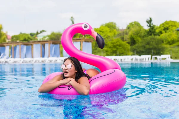 Sexy fille chaude s'assoit sur un matelas gonflable flamants roses dans la fête de la piscine . — Photo