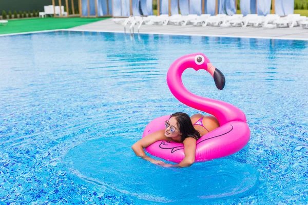 Sexy fille chaude s'assoit sur un matelas gonflable flamants roses dans la fête de la piscine . — Photo