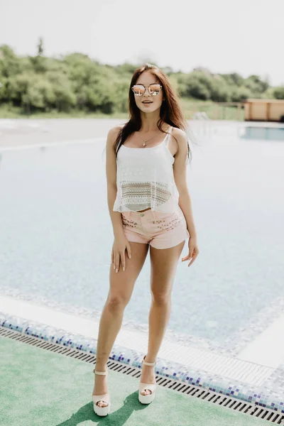 Vrouw in luxeresort in de buurt van zwembad. Zomer roeping — Stockfoto