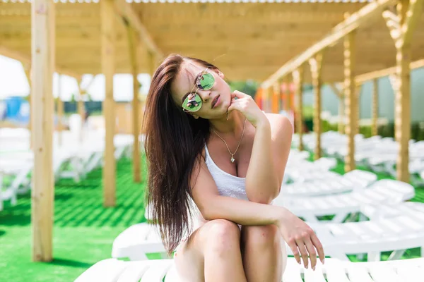 수영장 근처의 라운지의 자에 앉아 선글라스와 아름다움 여자. 여름 직업. — 스톡 사진