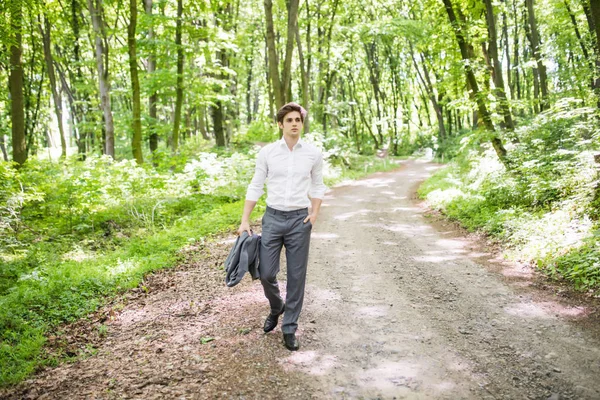 Bonito homem de negócios confiante em terno andando no parque verde. Conceito de negócio . — Fotografia de Stock