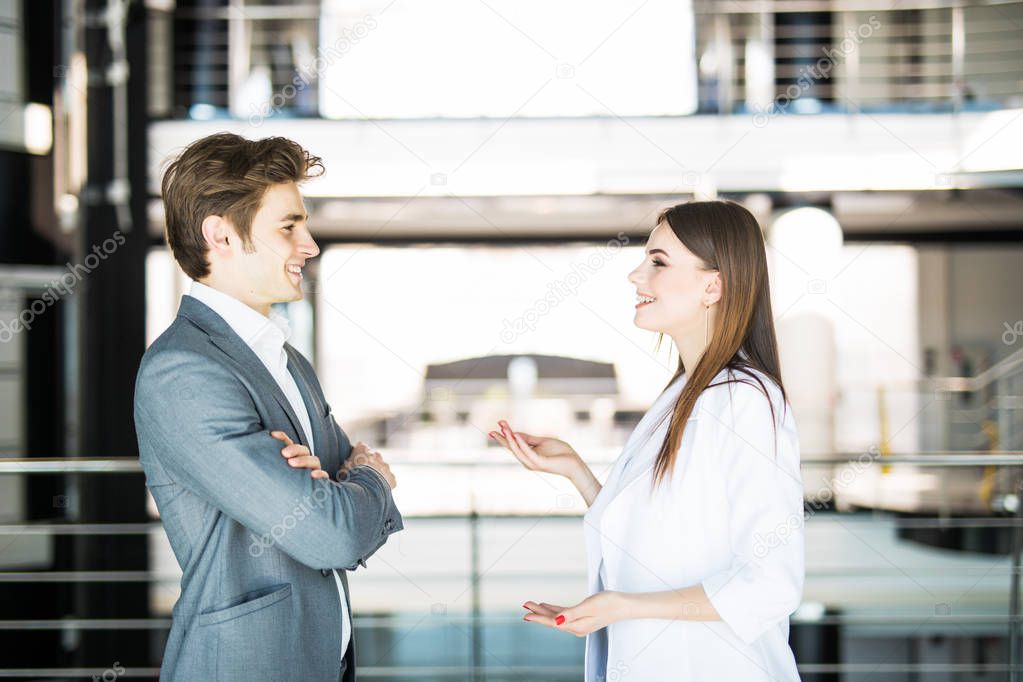 Cheerful businesswoman explain to her workmate talking in bright office. Business concept.