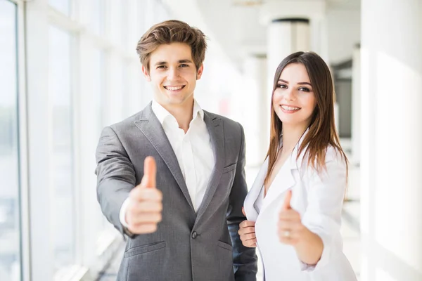 Business couple showing thumbs up in business office. Business woman and business man thumbs up. — Stock Photo, Image