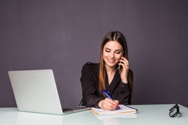 Genç ve çekici kadın cep telefonunuza konuşan ofiste çalışan telefon ve bir şey işaretlemek