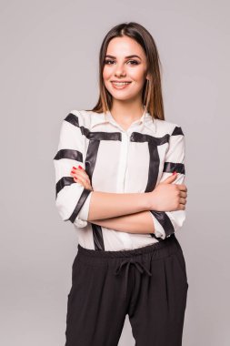 Gülümseyen iş kadın çapraz kolları olan arka plan ayakta gri studio karşı izole.