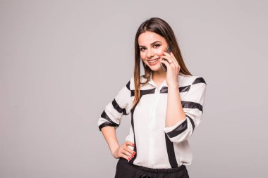 Cep telefonu gri bir arka plan üzerinde izole kahve yudumlarken konuşan şapkalı çekici genç bir kadın portresi