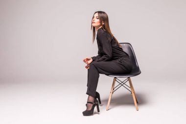 Korku veren beyaz çekici utangaç seksi kadın modeli tablo resmi bir takim elbisesi ve gri arka plan üzerinde izole, giyen Studio'da poz esmer saçlı