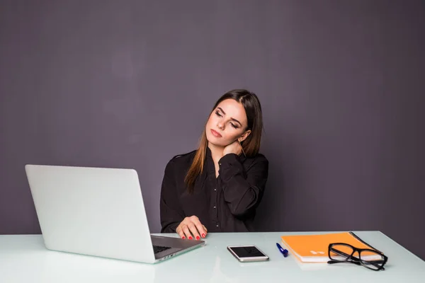 Affärskvinna i office arbetar med laptop. Kvinna sitter på hennes skrivbord händer på halsen av smärta — Stockfoto