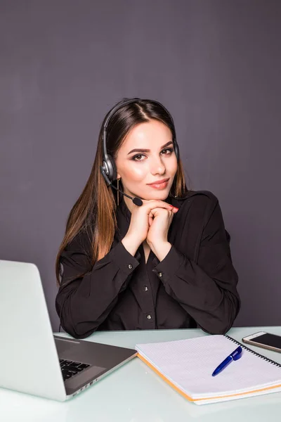 Hermosa mujer de negocios que trabaja en su escritorio con auriculares y portátil — Foto de Stock
