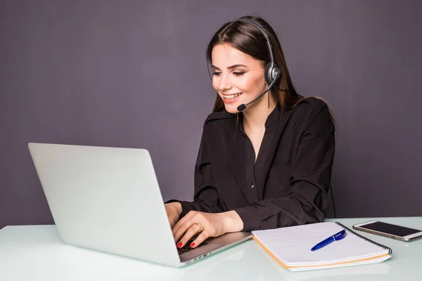 Casual customer support worker in office with headset and laptop in office