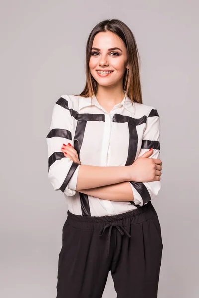 Mujer de negocios sonriente con brazos cruzados de pie contra un estudio gris fondo aislado . —  Fotos de Stock