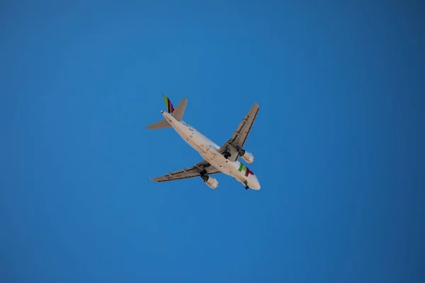 Un avión de pasajeros está volando en el cielo azul claro. Avión de pasajeros en el cielo azul — Foto de Stock