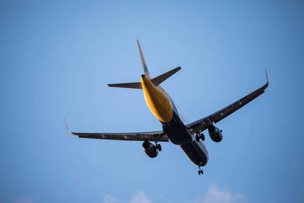 Um avião de passageiros está voando no céu azul claro. Avião de passageiros no céu azul — Fotografia de Stock